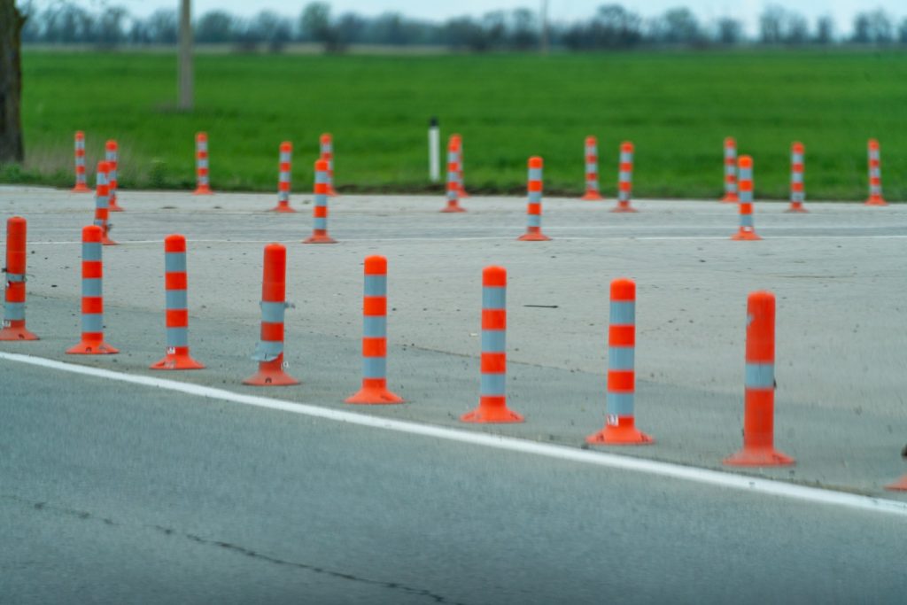 vecteezy-a-row-of-orange-and-white-traffic-cones-are-lined-up-on-a-47425283